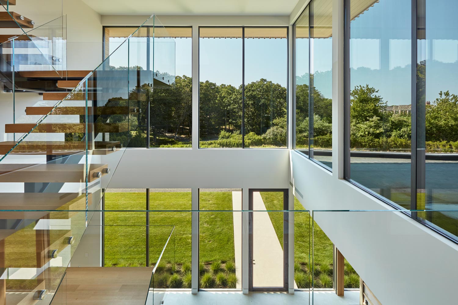 glass stair and double height entry in custom modern home