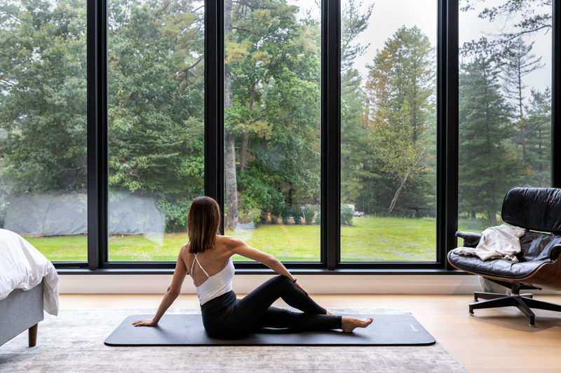 Automatic window shades in modern home gym area by The Up Studio.